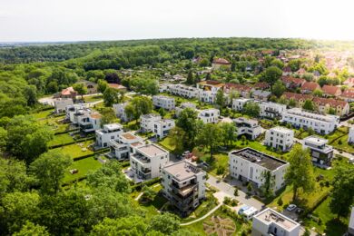 Vogelperspektive eines Baugebiets mit zahlreichen neugebauten Häusern, das die Entwicklung eines Wohngebiets in einer städtischen Umgebung zeigt